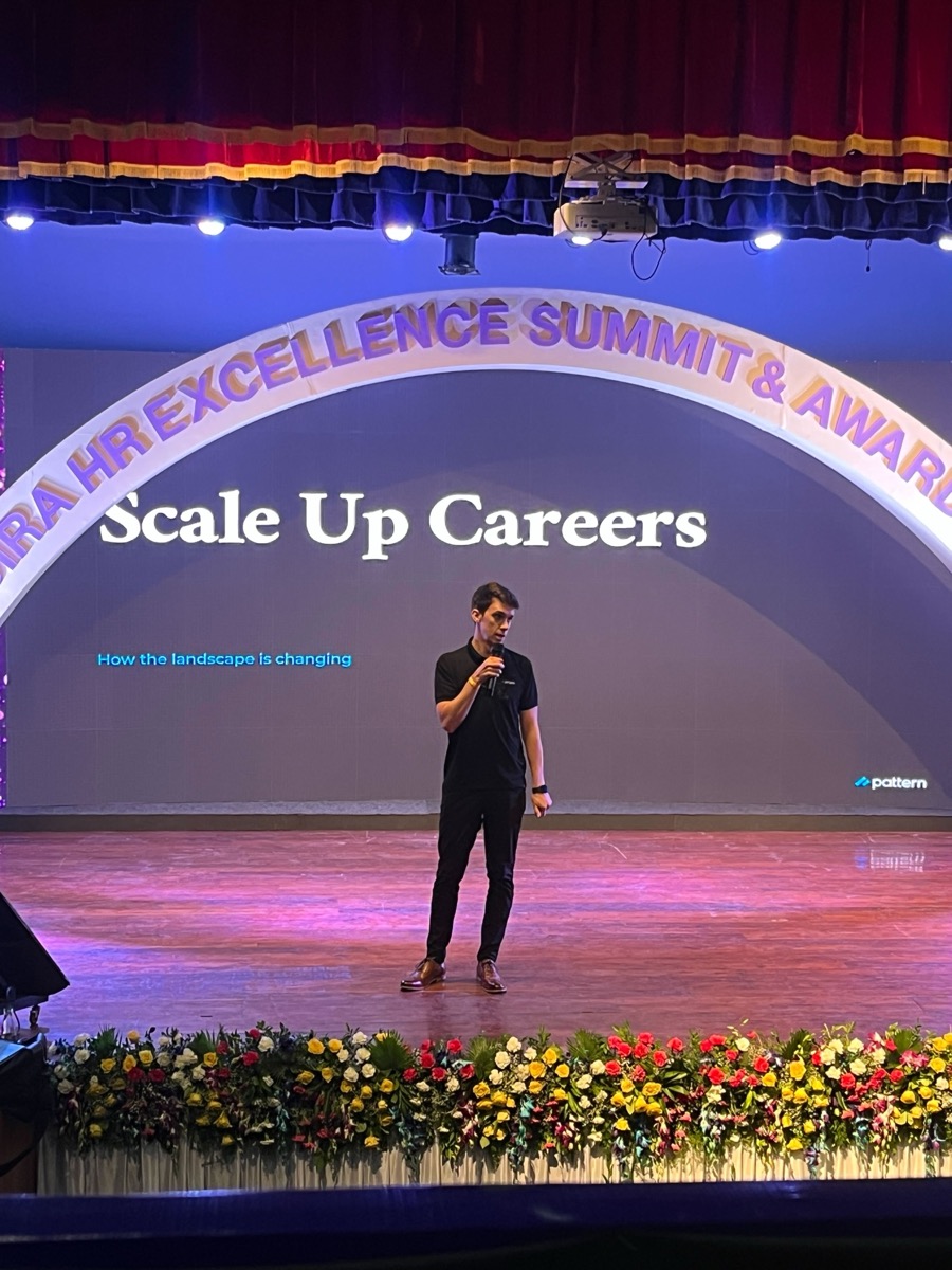 Broc speaking on stage at an industry event
